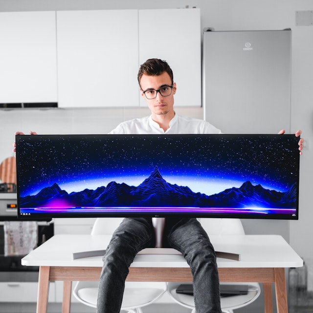 Man holding super ultrawide monitor